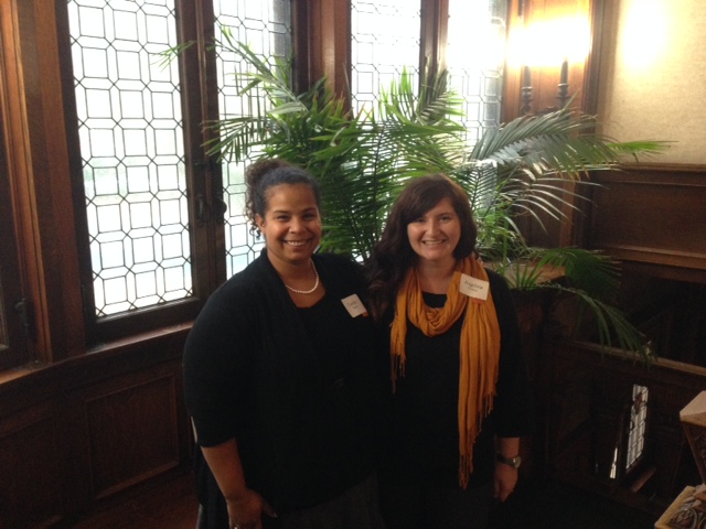 Two therapists who work with  women and children who have sought refuge from domestic violence at the YWCA Wege Sojourner House pose on the leaded-windowed landing of the shelter, a three-story Heritage Hill home built over a century ago.