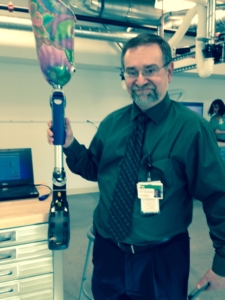 Patrick Logan, VP of Orthotics & Prosthetics, holds up one of Mary Free Bed’s more colorful prosthetic legs with the feet that spring up for running. 